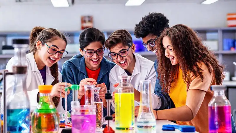 Estudiantes experimentando en laboratorio moderno y colorido