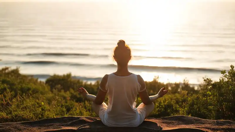 Persona serena meditando en entorno natural tranquilo