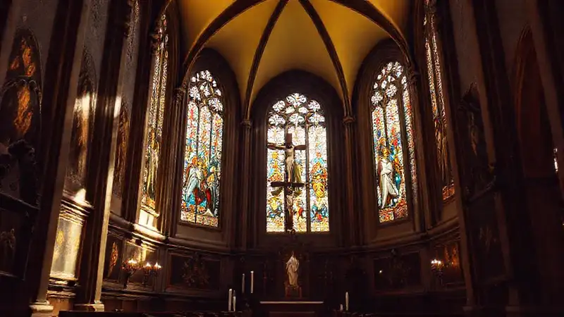 Interior de iglesia con vitrales y crucifijo dorado
