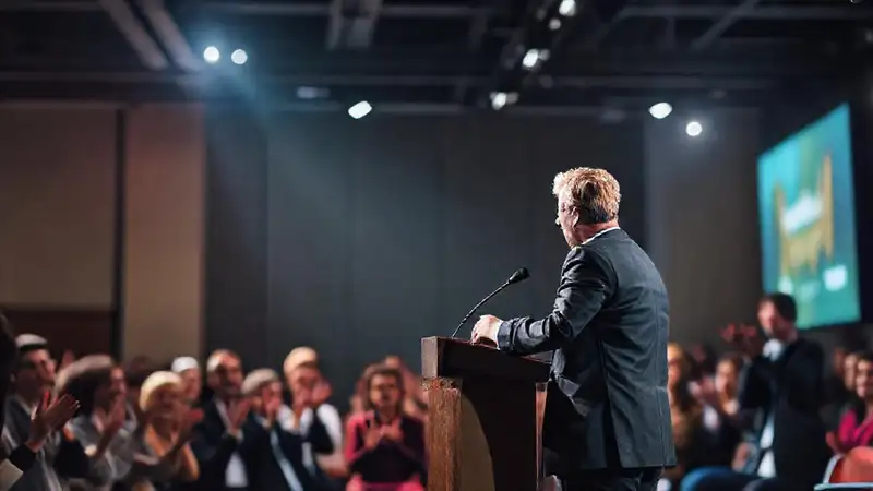 Orador confiado inspira audiencia en escenario profesional