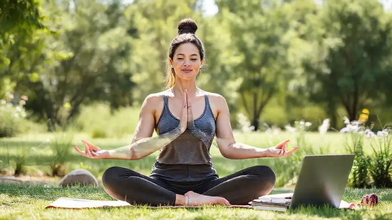 Mujer practicando yoga en entorno tranquilo natural