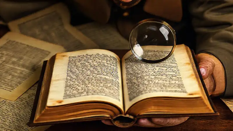 Libro antiguo con notas y lupa detallada