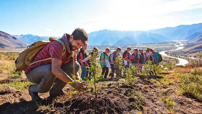 Estudiantes plantan árboles en paisaje natural